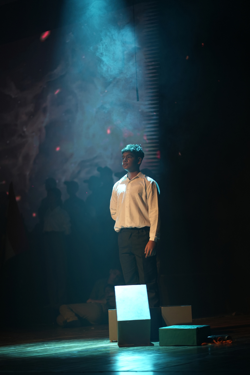 Actor standing alone in a spotlight on stage