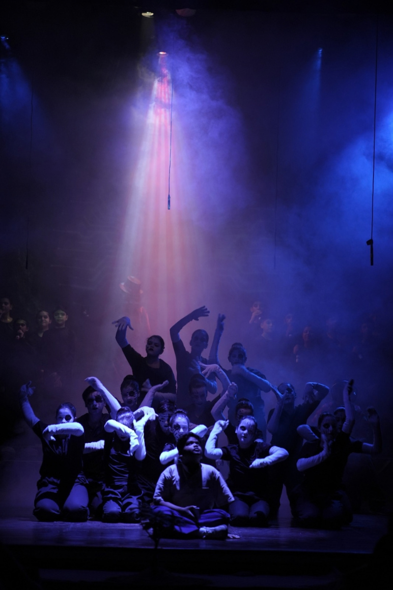 Ensemble performing under purple stage light